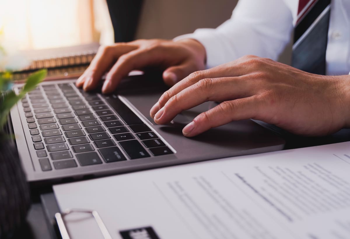 Business professional reviewing records on a laptop