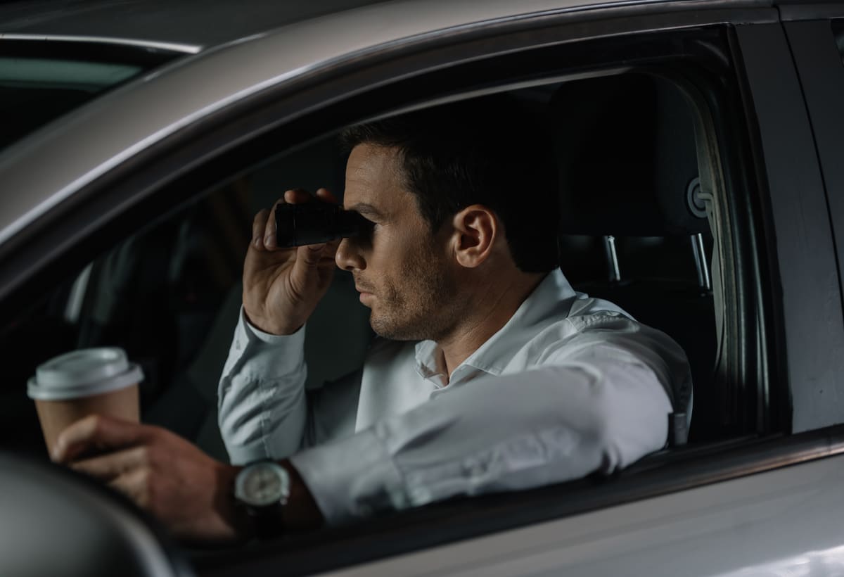 Undercover investigator doing surveillance from a parked vehicle