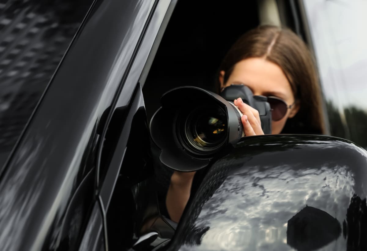 Discreet investigator taking photos from a vehicle window