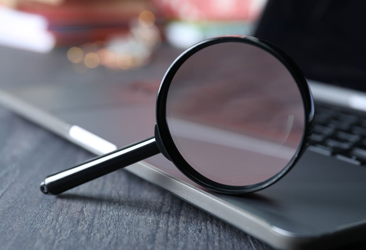 Magnifying glass and laptop used for locate research